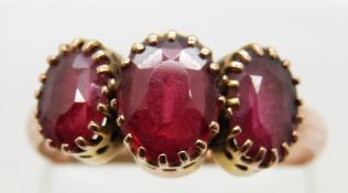 A 9ct gold ring set with three garnets, size P, 2.