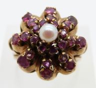 A 14K gold ring set with rubies and a pearl in a tiered setting, size Q, 6.