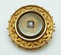 A yellow metal Victorian mourning brooch set with an old cut diamond with a foliate border,