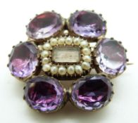 A Victorian mourning brooch set with a glass compartment to the centre surrounded by seed pearls