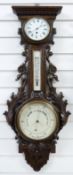 Early 20thC English aneroid clock / barometer compendium in carved oak case,