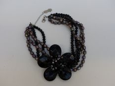 A Butler & Wilson necklace made up of faceted black beads and petals and grey pearls,
