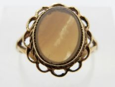 A 9ct gold ring set with a agate within a pierced border, size J/K, 3.