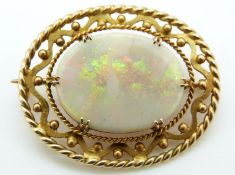 A 9ct gold brooch set with an opal with pierced border
