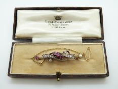 A late 19th/ early 20thC gold brooch set with diamonds, rubies and a pearl,