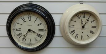 Two Newgate quartz dial wall clocks with Roman numerals, one in black the other mushroom finish,