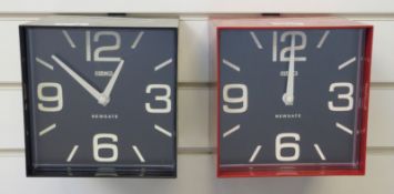 Two Newgate quartz 'cube' clocks, one in red the other in black finish, with black Arabic dials,