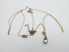 A 9ct gold pendant set with a pear cut blue topaz and diamonds on a 9ct gold chain (2.