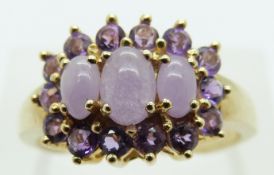 A 9ct gold ring set with three amethyst cabochon surrounded by further amethysts, size S, 4.