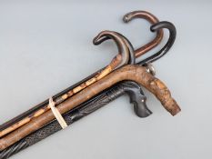 Seven various walking sticks and canes to include four hallmarked silver mounted examples,