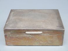 A hallmarked silver cigarette box with engine turned decoration, Birmingham 1961 maker's mark T&S.