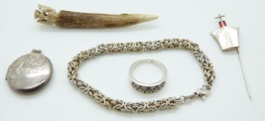A silver locket, silver ring set with sapphires, a stick pin in the form of a ship,