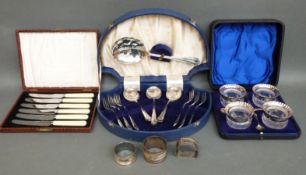 Three hallmarked silver napkin rings, four cased glass salts with spoons,
