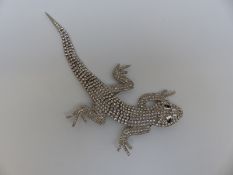 A Butler & Wilson brooch in the form of a lizard set with clear paste with black eyes,