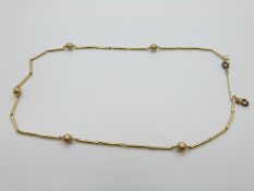 An 18ct gold necklace made up of spherical and elongated links, 7.