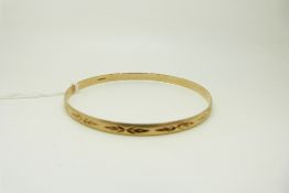 A 9ct gold bangle with cut out design