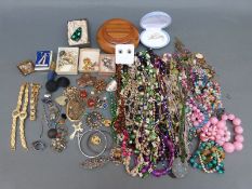 A collection of costume jewellery including beads, brooches,