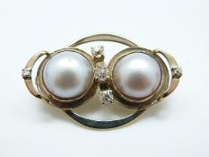 A 9ct gold brooch/ pendant set with two Mabé pearls and five old cut diamonds the largest