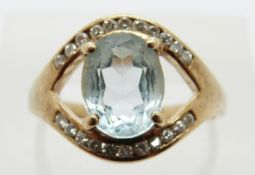 A 9ct gold ring set with an oval aquamarine and diamonds, size O, 4.