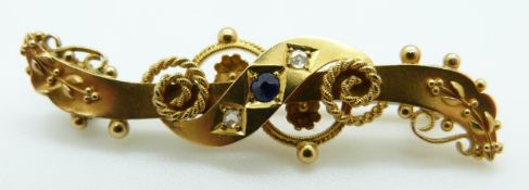 A 15ct gold brooch set with two small diamonds and a sapphire