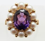 An 18ct gold ring set with an oval synthetic purple sapphire surrounded by pearls, size N, 5.