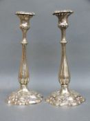 A pair of plated candlesticks with relief decoration of foliage, 28.