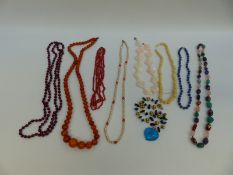 A collection of beaded necklaces including pressed amber, coral, agate,