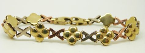 A 9ct tri-coloured bracelet of cross and floral design, 11.