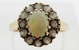 A 9ct gold ring set with an opal surrounded by paste, size K, 2.