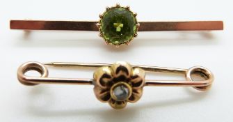 A 9ct gold brooch set with a round cut peridot and a yellow metal brooch set with a rose cut