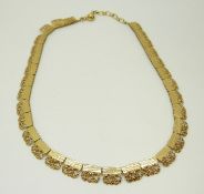 A 9ct gold necklace made up of textured and pierced sections, 17.