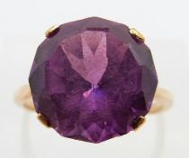 A yellow metal ring set with a large synthetic purple sapphire, size P, 4.