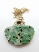 A yellow metal chain and pendant set with a jadeite plaque depicting two flowers