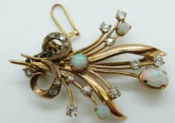 A gold brooch set with four opal cabochons and diamonds in a stylized bouquet design