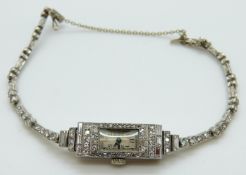 An Art Deco platinum cocktail watch set with baguette and round cut diamonds to the rectangular