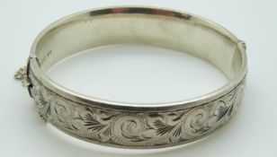 A silver bangle with engraved detail to one side, maker Georg Jensen.
