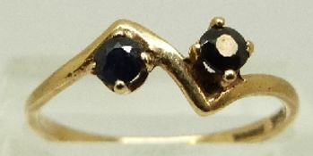 A 9ct gold ring set with two sapphires, size O, 1.