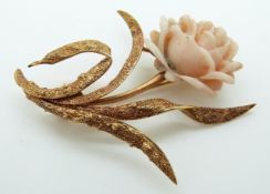 A 14ct gold brooch in the form of a rose set with a coral flower and textured leaves (15.