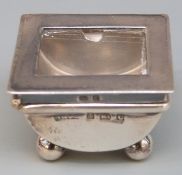 Edward VII hallmarked silver stamp case with glazed lid, raised on four ball feet,