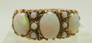 A 9ct gold ring set with three oval opals and six round opal cabochons, size O, 3.6g.