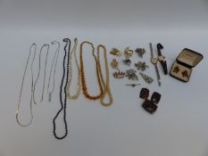 A collection of costume jewellery including silver brooch, other brooches, mother-of-pearl necklace,