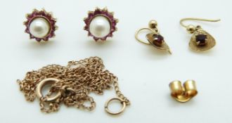 A pair of 9ct gold earrings set with a pearl surrounded by rubies,