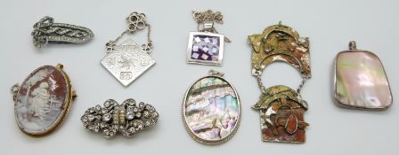 A silver metamorphic brooch set with paste, a cameo brooch, silver pendant set with mother of pearl,