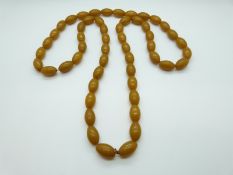An amber style necklace of 53 beads, each 22 x 14mm,