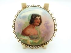 A 9ct gold brooch set with a painted portrait of a woman on ceramic