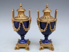 A pair of continental ormolu and porcelain lidded urns, 18.