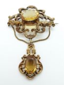 A Victorian brooch with overall engraved foliate decoration set with two oval citrines