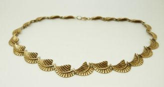 A 9ct gold necklace made up of stylised leaf links, 23.