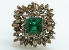 An 18ct white gold ring set with a square cut emerald of approximately 1ct surrounded by baguette
