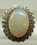 A 9ct gold ring set with a large opal cabochon surrounded by diamonds, size L, 4.1g.